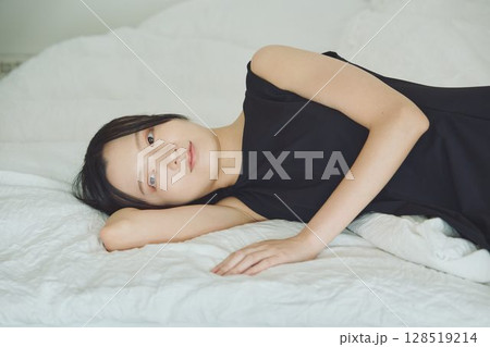 ベッドで寝ている若い女性 128519214