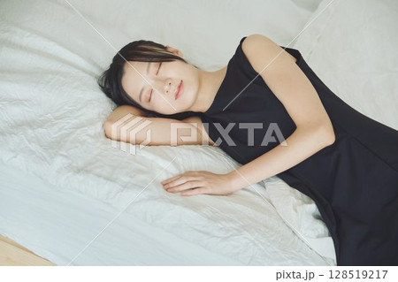ベッドで寝ている若い女性 128519217