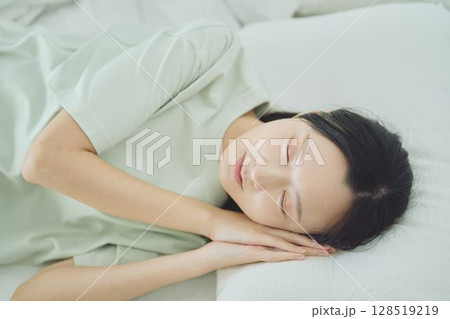 ベッドで寝ている若い女性 128519219