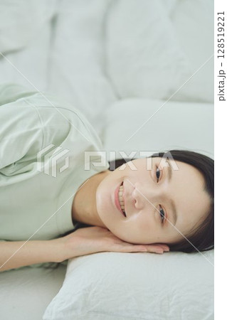 ベッドで寝ている若い女性 128519221