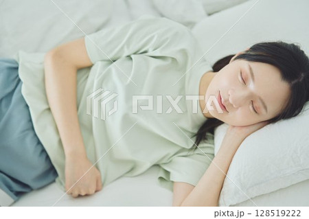 ベッドで寝ている若い女性 128519222