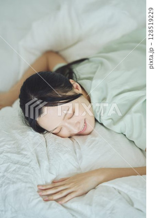 ベッドで寝ている若い女性 128519229