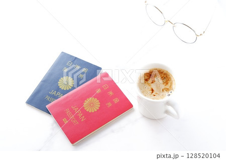 パスポート(10年用赤色と5年用紺色)を用意して、コーヒーを飲みながら海外旅行を計画しているイメージ パスポート(10年用赤色と5年用紺色)を用意して、コーヒーを飲みながら海外旅行を計画しているイメージ 128520104