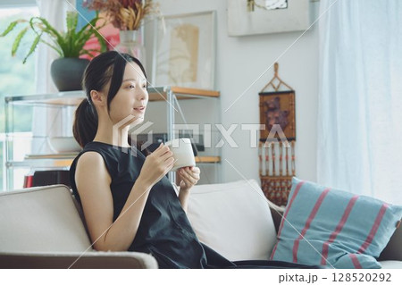 リビングでコーヒーを飲む女性 128520292