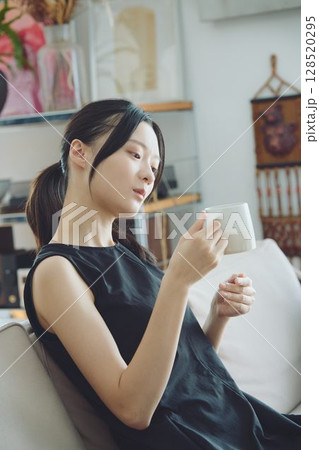 リビングでコーヒーを飲む女性 リビングでコーヒーを飲む女性 128520295