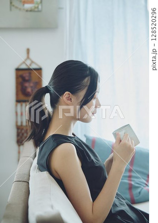 リビングでコーヒーを飲む女性 128520296