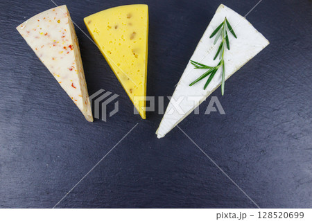 Set of various types of cheese on black slate background. Top view Set of various types of cheese on black slate background. Top view 128520699