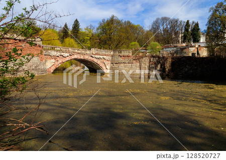 Old arched brick bridge across a pond in Sharovka Palace park in in Kharkov region, Ukraine Old arched brick bridge across a pond in Sharovka Palace park in in Kharkov region, Ukraine 128520727