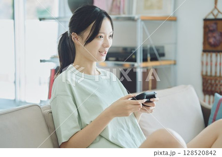 リビングでゲームをする女性 128520842