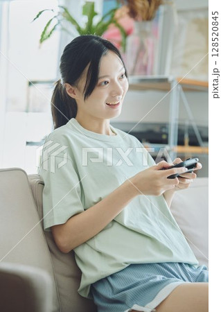 リビングでゲームをする女性 リビングでゲームをする女性 128520845
