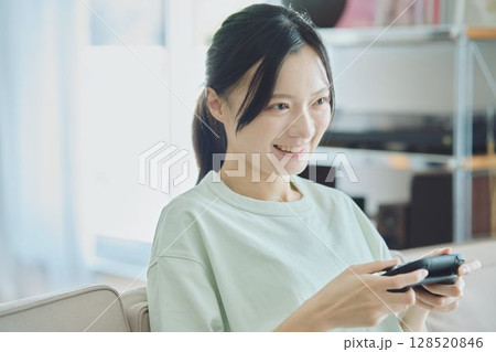 リビングでゲームをする女性 リビングでゲームをする女性 128520846