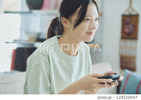 リビングでゲームをする女性 リビングでゲームをする女性 128520847