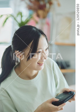リビングでゲームをする女性 128520850