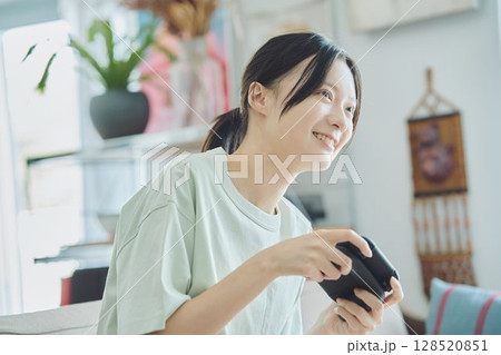 リビングでゲームをする女性 リビングでゲームをする女性 128520851