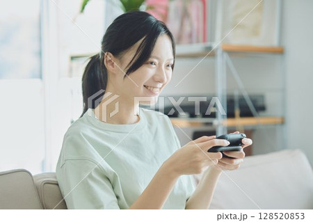 リビングでゲームをする女性 リビングでゲームをする女性 128520853