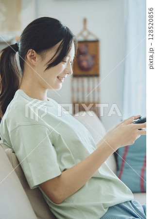 リビングでゲームをする女性 128520856