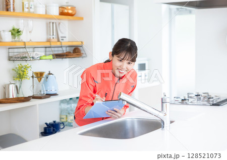 ハウスクリーニング　キッチンを点検するスタッフ 128521073