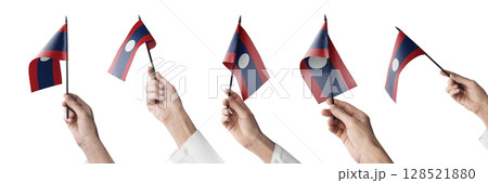 The Laos flag in hand in different angles on a white background The Laos flag in hand in different angles on a white background 128521880