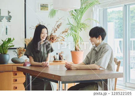 リビングでくつろぐ若い夫婦 リビングでくつろぐ若い夫婦 128522105