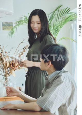 リビングでくつろぐ若い夫婦 128522120