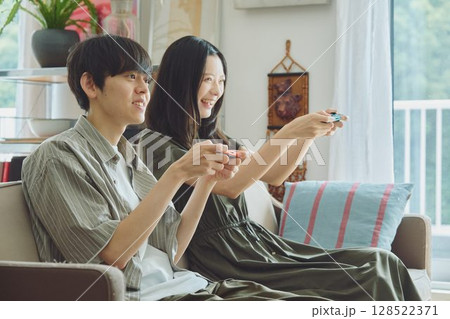 リビングでゲームをする若い夫婦 128522371