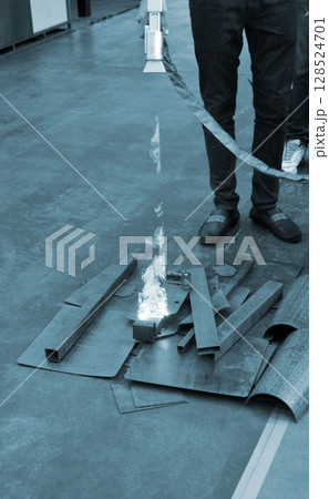 Person cleaning metal surface from rust with laser. Laser cleaning metal surfaces. Laser cleaning metal from rust. Glowing laser beam cleansing metal. Glowing beam removes removing old dirt metallic 128524701