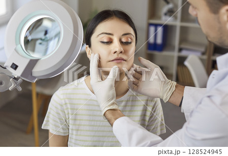 Plastic Surgeon Consulting Patient In Clinic 128524945