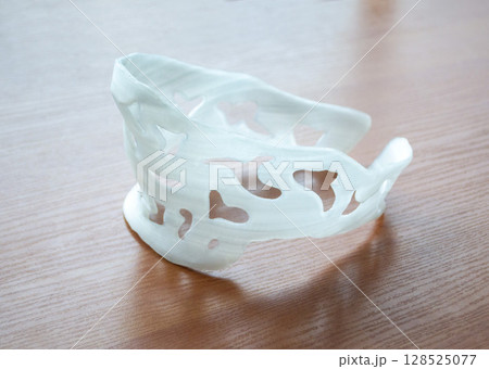 Plastic neck splint corset prosthesis. Neck prosthesis corset langet printed on 3D printer from molten plastic. Medical orthosis, fixator, plastic overlay created on 3D printer. Printing technologies 128525077