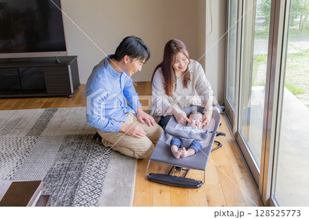 赤ちゃんをあやす夫婦 128525773