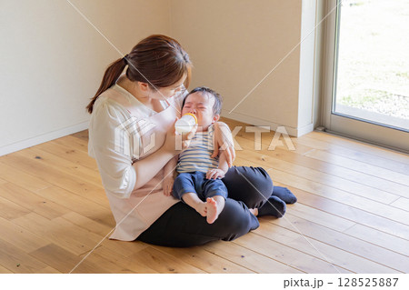 赤ちゃんにミルクを与える保育士 128525887