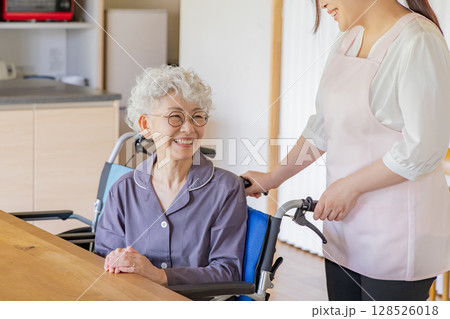 介護車椅子のシニアの女性とヘルパー 128526018