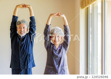 パジャマで柔軟体操をするシニアカップル 128526046