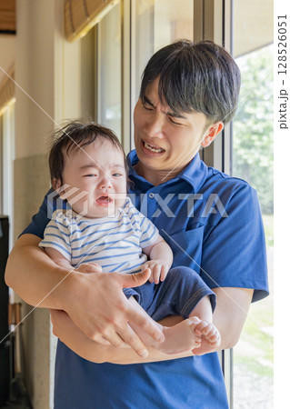 赤ちゃんを抱っこする保育士 128526051