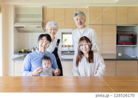 喜ぶ三世代家族の集合写真 128526170