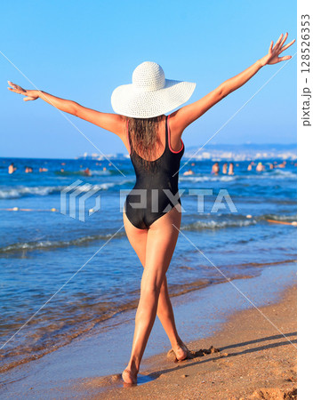 Sexy gorgeous woman with beautiful slim body is posing on a sandy sea beach, summer holidays concept, pretty girl 128526353