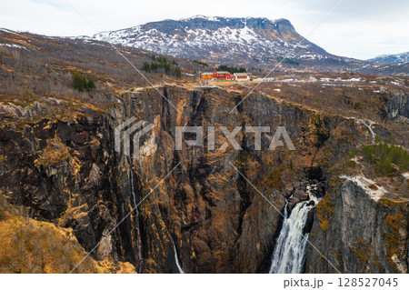 Powerful Voringsfossen waterfall with cascades plunging dramatically into gorge below. Steep cliffs emphasize sheer scale and raw beauty of Norway Powerful Voringsfossen waterfall with cascades plunging dramatically into gorge below. Steep cliffs emphasize sheer scale and raw beauty of Norway 128527045