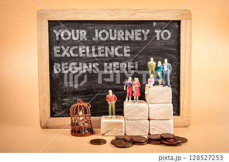 Motivational Journey to Excellence Concept with Figurines, Chalkboard, Wooden Blocks, and Coins Motivational Journey to Excellence Concept with Figurines, Chalkboard, Wooden Blocks, and Coins 128527253
