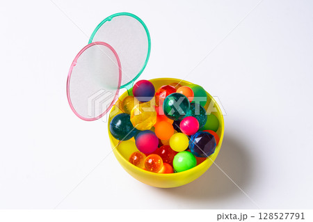 カップに入ったカラフルなスーパーボールとポイ 128527791