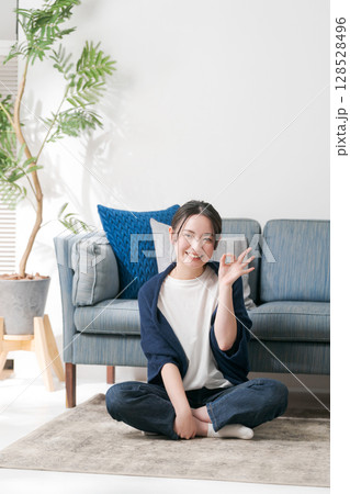 リビングでくつろぐ若い女性 リビングでくつろぐ若い女性 128528496