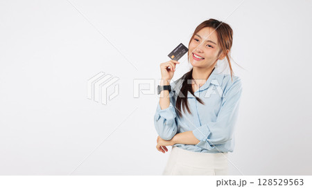 Happy young asian woman hold credit card thinking money payment options while looking at copy space, she is dreaming and ready to use her bank card, isolated studio white background 128529563