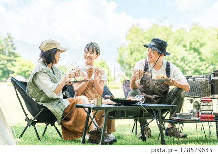 公園・キャンプ場でデイキャンプ・キャンプ・バーベキューを楽しむ仲良しのファミリー 128529635