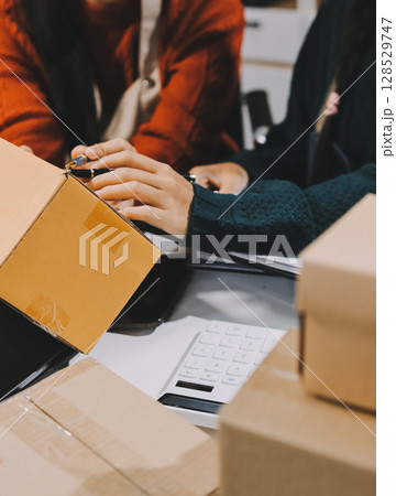 Portrait of Starting small businesses SME owners, two Asian woman check online orders Selling products working with boxs freelance work at home office, sme business online small medium enterprise 128529747