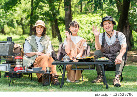 公園・キャンプ場でデイキャンプ・キャンプ・バーベキューを楽しむ仲良しのファミリー 128529796