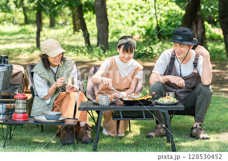 公園・キャンプ場でデイキャンプ・キャンプ・バーベキューを楽しむ仲良しのファミリー 128530452