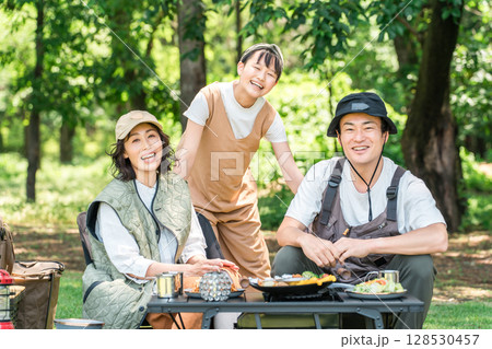 公園・キャンプ場でデイキャンプ・キャンプ・バーベキューを楽しむ仲良しのファミリー 128530457