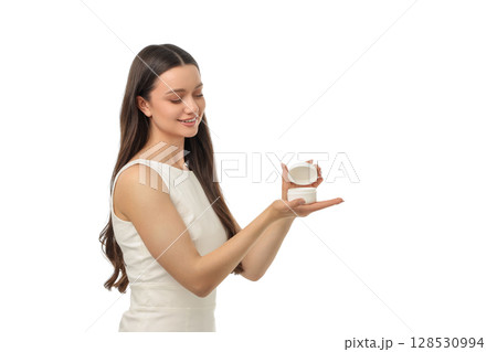 Woman happily showcases a skincare jar in her palm, isolated on white, PNG Woman happily showcases a skincare jar in her palm, isolated on white, PNG 128530994