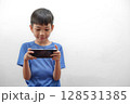 Asian Boy Playing Game Mobile Phone in Landscape Mode. Technology Use in Childhood 128531385