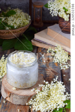 Elderflower sugar and blossom flower in wooden background. Edible elderberry flowers add flavour and aroma to drink and dessert. Copy space 128531598