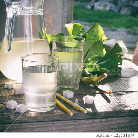 Refreshing healthy summer drink with rhubarb. Pieplant lemonade in glass on wooden background. Homemade rhabarbarum compote. 128531674