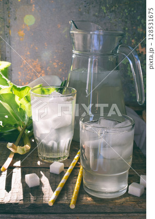 Refreshing healthy summer drink with rhubarb. Pieplant lemonade in glass on wooden background. Homemade rhabarbarum compote. Refreshing healthy summer drink with rhubarb. Pieplant lemonade in glass on wooden background. Homemade rhabarbarum compote. 128531675
